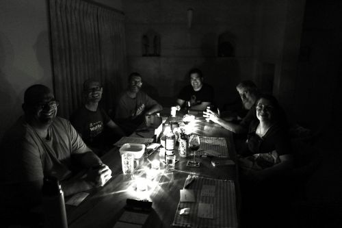 Group lit by candlelight ready to play the tragic horror game 10 candles